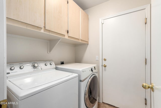 laundry room featuring cabinets and washer and clothes dryer