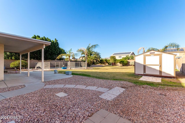 view of yard with a shed and a patio area