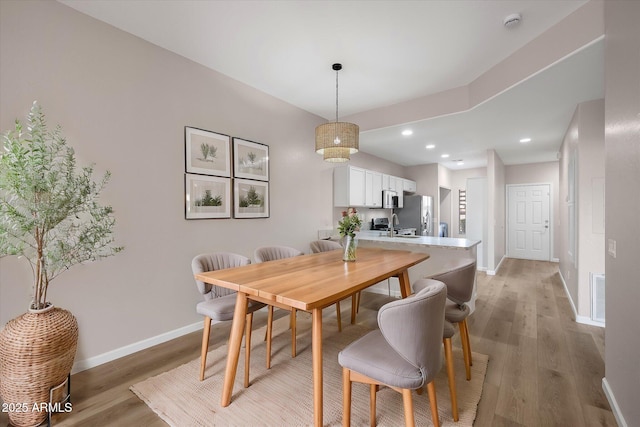 dining room featuring sink and light hardwood / wood-style flooring