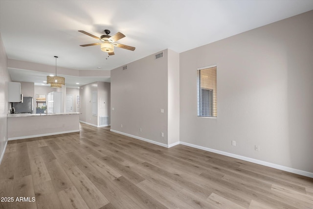 unfurnished living room with light wood-type flooring and ceiling fan