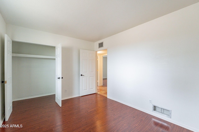 unfurnished bedroom featuring dark wood-type flooring and a closet