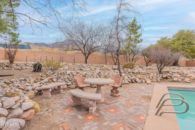 view of patio featuring a mountain view and a fenced in pool