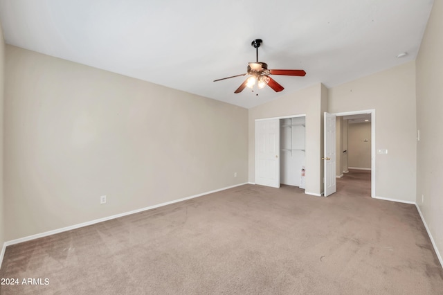 unfurnished bedroom with ceiling fan, lofted ceiling, carpet, and a closet