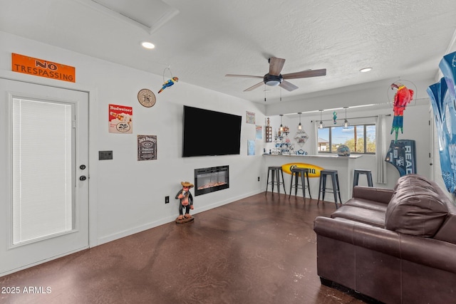 665 W Chaparral Rd, Wickenburg, AZ 85390 - living room featuring a glass covered fireplace, concrete floors, baseboards, a ceiling fan, and recessed lighting