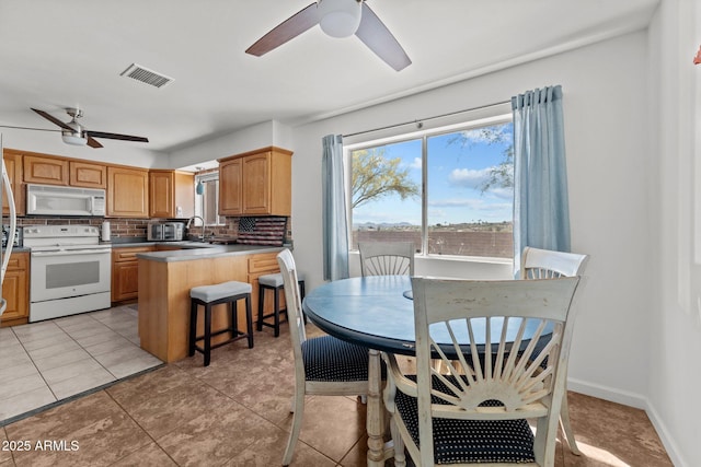 665 W Chaparral Rd, Wickenburg, AZ 85390 - kitchen with white appliances, a ceiling fan, decorative backsplash, and plenty of natural light