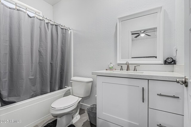 32102 N Walnut St, Wittmann, AZ 85361 - bathroom featuring toilet, vanity, shower / tub combo with curtain, a textured wall, and ceiling fan