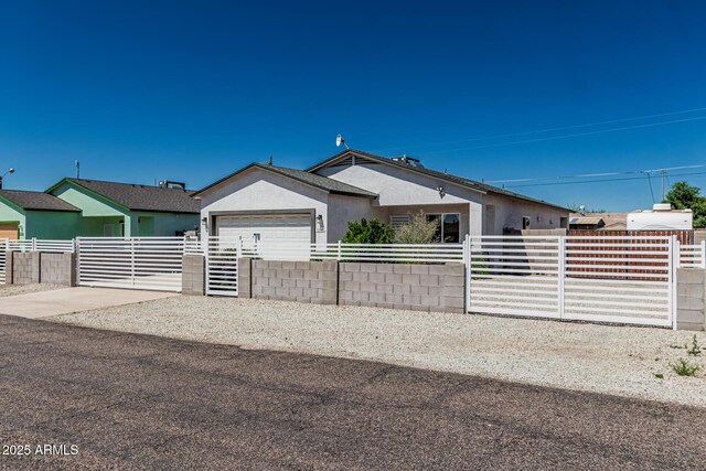 32102 N Walnut St, Wittmann, AZ 85361 - view of front of house with a fenced front yard, an attached garage, stucco siding, and driveway