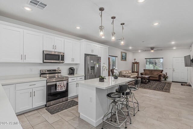 32102 N Walnut St, Wittmann, AZ 85361 - kitchen with appliances with stainless steel finishes, open floor plan, white cabinets, recessed lighting, and a breakfast bar