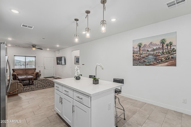 32102 N Walnut St, Wittmann, AZ 85361 - kitchen with freestanding refrigerator, a kitchen breakfast bar, open floor plan, ceiling fan, and white cabinets