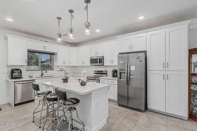 32102 N Walnut St, Wittmann, AZ 85361 - kitchen with appliances with stainless steel finishes, a sink, white cabinets, light countertops, and a kitchen breakfast bar
