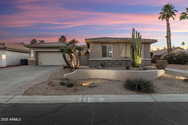 view of front of property featuring a garage and central air condition unit