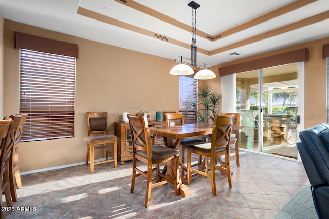 tiled dining room featuring a tray ceiling