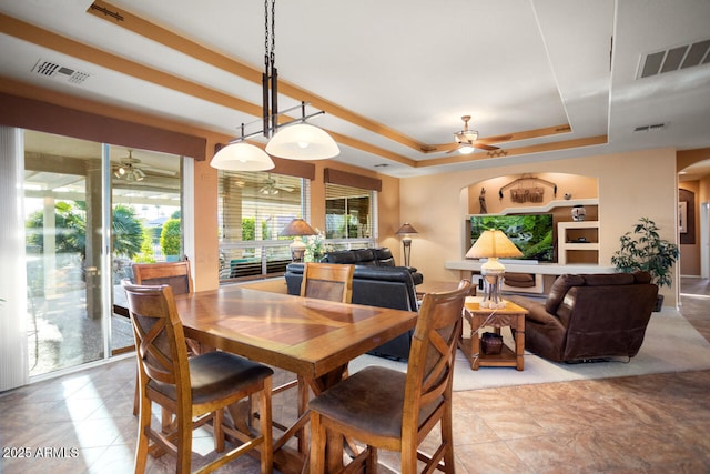 dining room featuring built in features and a tray ceiling