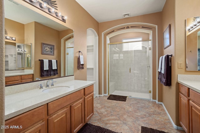 bathroom with walk in shower and vanity