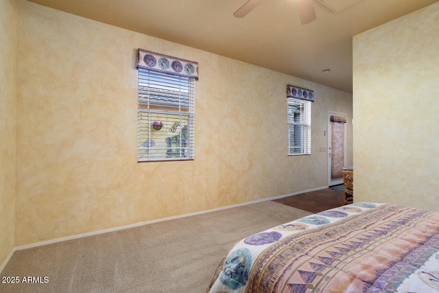 bedroom featuring ceiling fan, multiple windows, and carpet