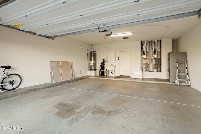 garage with a garage door opener, refrigerator, and gas water heater