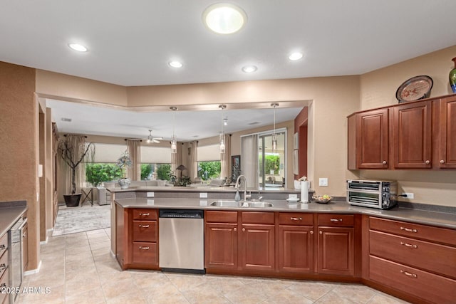 kitchen with a peninsula, a toaster, open floor plan, a sink, and dishwasher