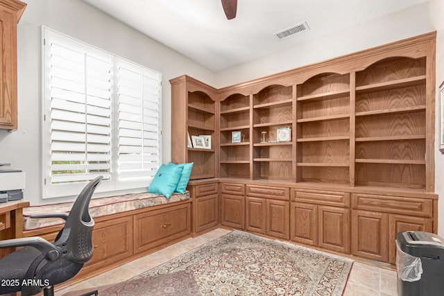 unfurnished office with light tile patterned floors, a ceiling fan, and visible vents