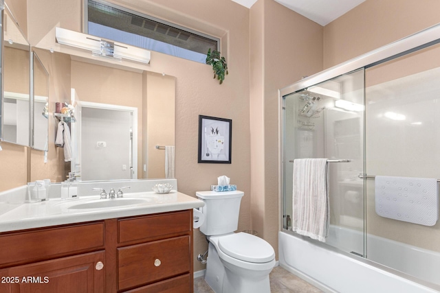 full bath with vanity, combined bath / shower with glass door, tile patterned flooring, and toilet