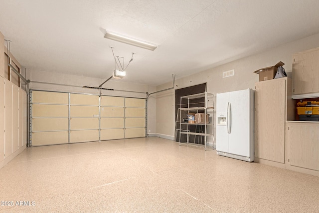 garage with white fridge with ice dispenser and a garage door opener