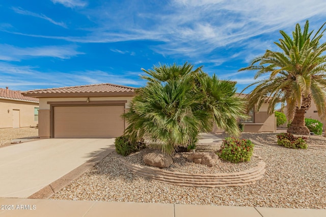 view of front of property with a garage, stucco siding, driveway, and a tile roof