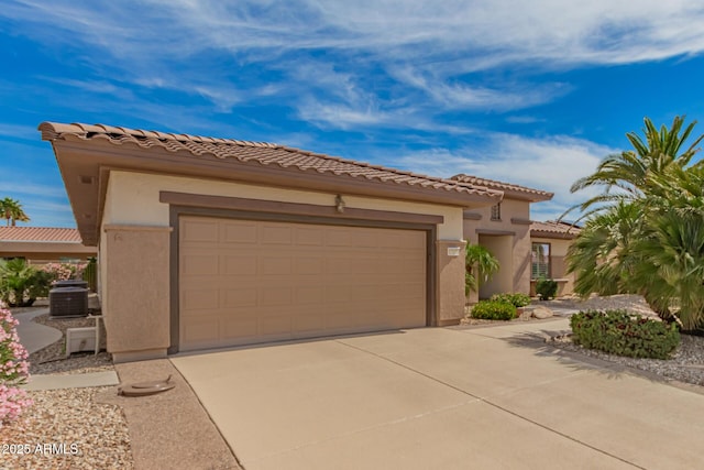 mediterranean / spanish house with an attached garage, stucco siding, driveway, and cooling unit