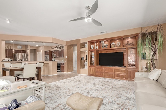 living area with a ceiling fan and visible vents