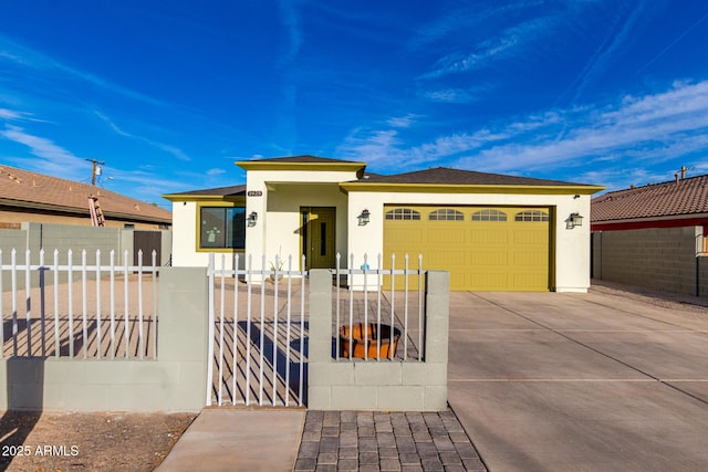 prairie-style home featuring a fenced front yard, concrete driveway, an attached garage, and stucco siding