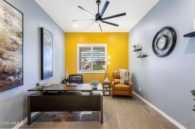 carpeted office with a ceiling fan and baseboards