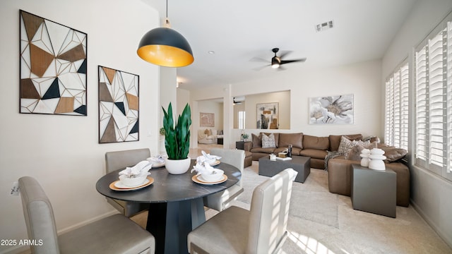 carpeted dining area with ceiling fan