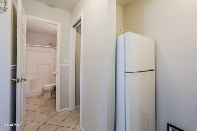 bathroom with tile patterned flooring, toilet, and shower / washtub combination