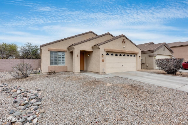 view of front of house featuring fence, driveway, stucco siding, a garage, and a tiled roof