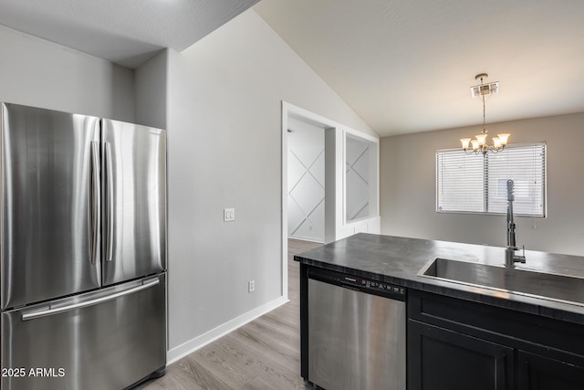 kitchen with visible vents, a sink, vaulted ceiling, appliances with stainless steel finishes, and dark cabinets