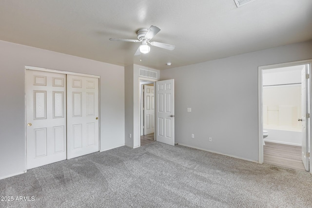 unfurnished bedroom with visible vents, carpet, a closet, and ensuite bathroom