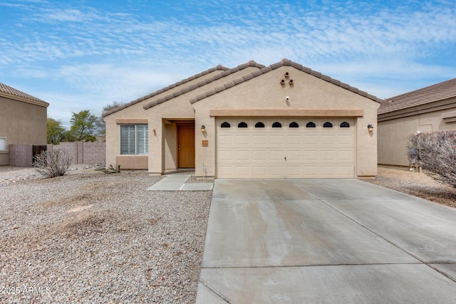 view of front of home featuring stucco siding, a garage, concrete driveway, and fence