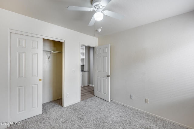 unfurnished bedroom with baseboards, a closet, carpet floors, and ceiling fan