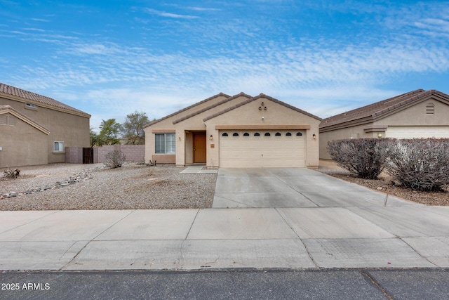 view of front of property featuring stucco siding, an attached garage, driveway, and fence