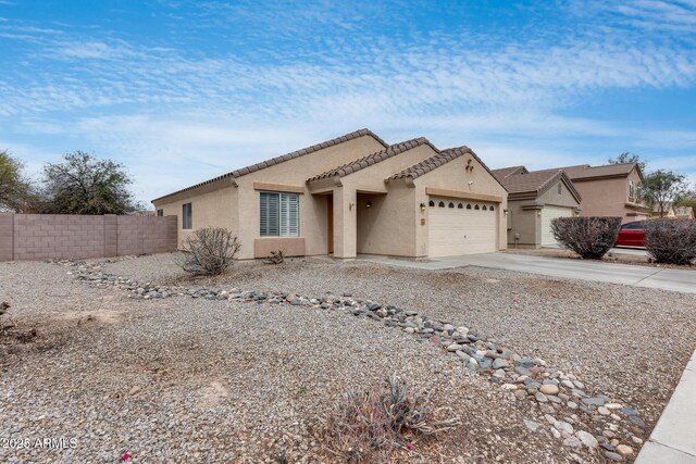 view of front of home with fence, an attached garage, stucco siding, concrete driveway, and a tiled roof