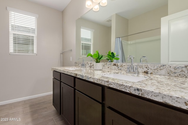 bathroom featuring walk in shower, wood-type flooring, and vanity