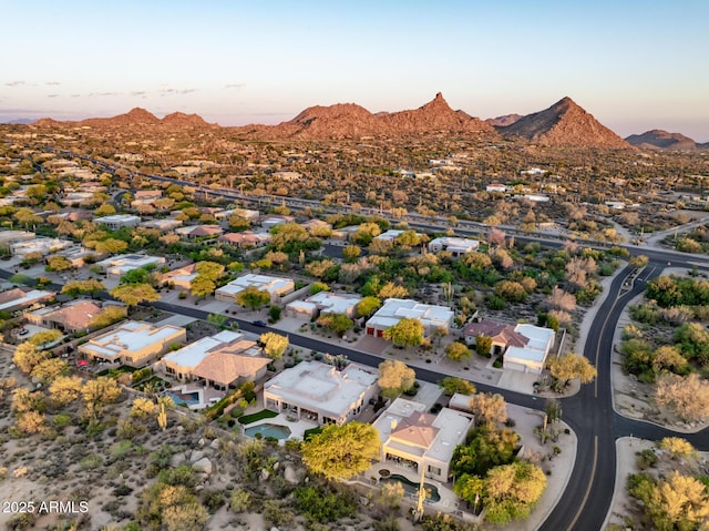 aerial overview of property's location with a mountainous background and nearby suburban area