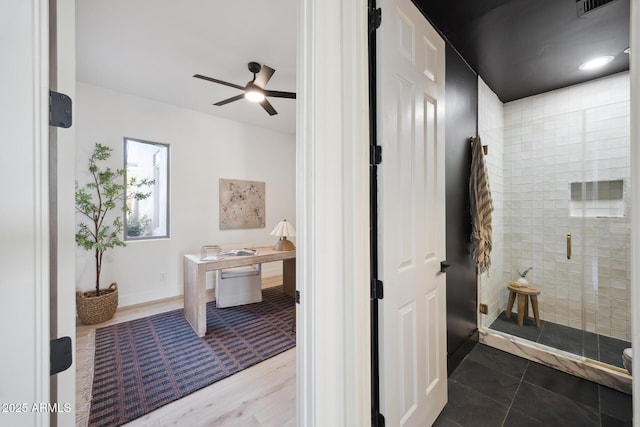 bathroom featuring a shower stall and ceiling fan