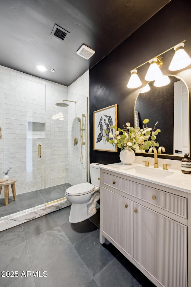 bathroom with toilet, vanity, and a stall shower
