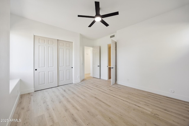 unfurnished bedroom with wood finished floors, baseboards, a closet, and a ceiling fan