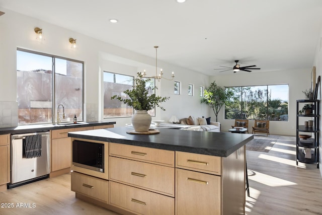 kitchen with light brown cabinetry, dishwasher, built in microwave, healthy amount of natural light, and recessed lighting