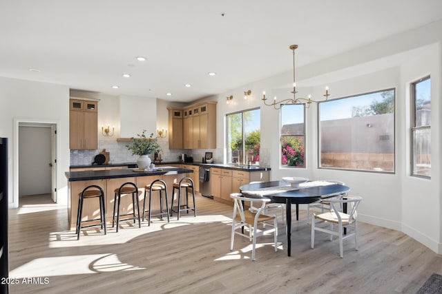 dining space featuring light wood-type flooring, recessed lighting, a chandelier, and baseboards