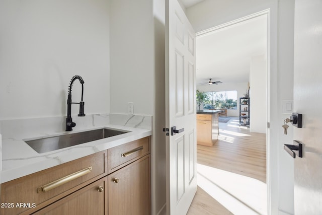 bar with a sink and light wood-style floors