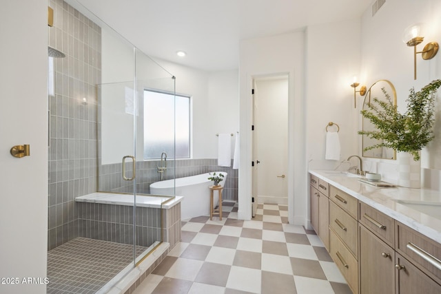 bathroom featuring a shower stall, tile patterned floors, double vanity, a freestanding bath, and tile walls