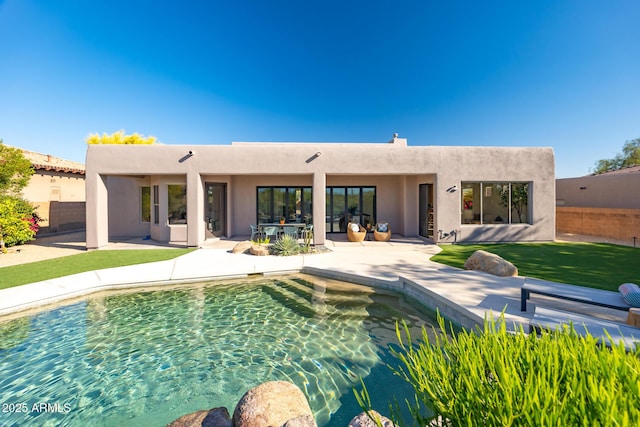 back of house featuring stucco siding, fence, and a patio