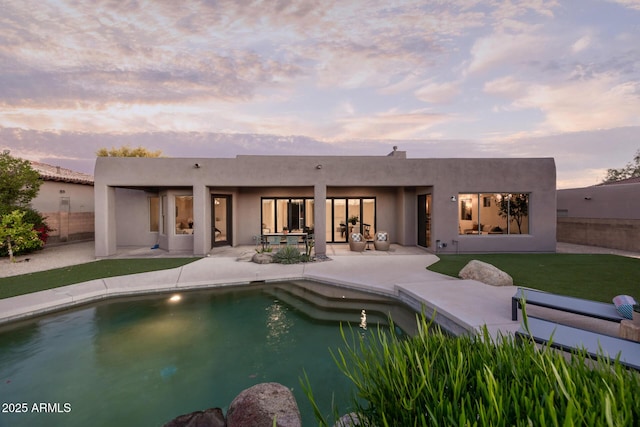 back of house with a patio, stucco siding, and fence
