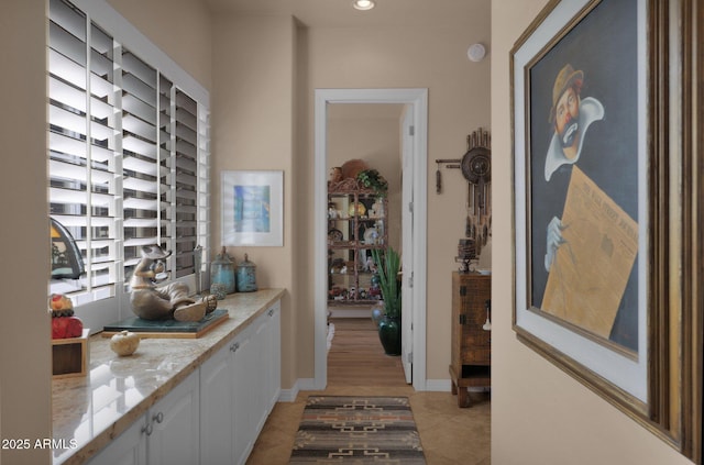 hall with light tile patterned floors, baseboards, and recessed lighting